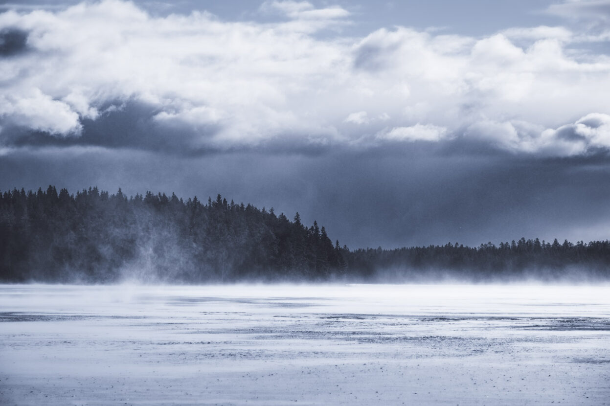 Sweden, the wind blowing on a frozen forest lake
