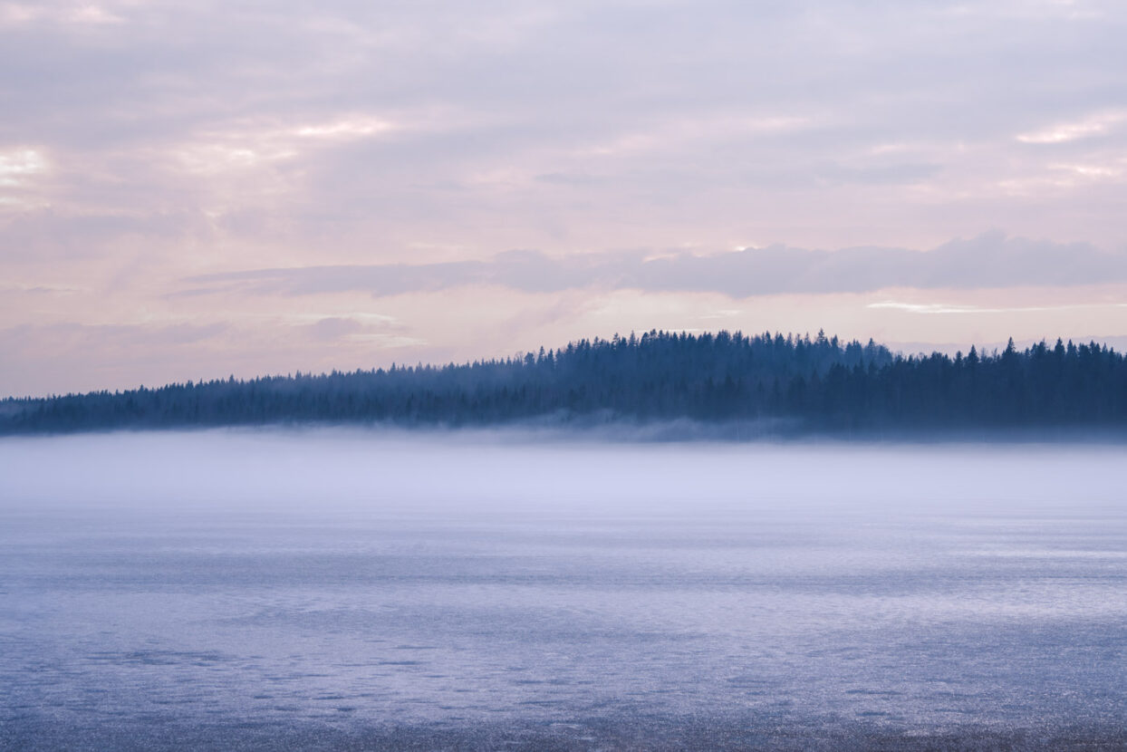 Dawn mist on a frozen lake in Sweden